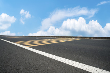 Road pavement under blue sky and white clouds