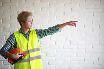 Asian man in protective helmet and construction waistcoat