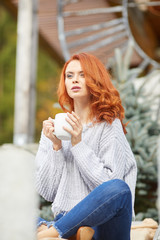 Outdoors autumn portrait of beautiful woman with red hair