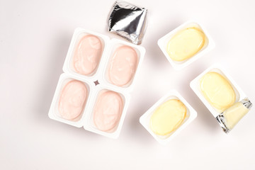 Plastic cup with tasty yogurt isolated on white. Top view. Space for text or design.