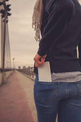 Attractive woman holding cellphone in pocket.
