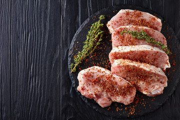 Top view on chops of pork, black background