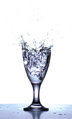 ice cubes splashing in clear water glass