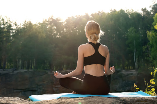 Beautiful Young Woman Practicing Yoga Outdoors In Morning