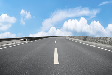 Road pavement under blue sky and white clouds