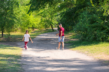 Little boy with his dad playing football outdoors