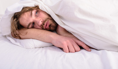 Fototapeta na wymiar Guy lay under white bedclothes. Fresh bedclothes concept. Man unshaven handsome relaxing bed. Let your body feel comfortable. Man sleepy drowsy unshaven bearded face covered with blanket having rest