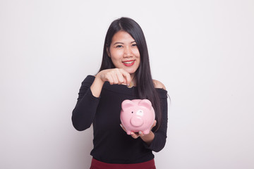 Asian woman with coin and pig coin bank.