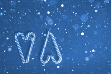blue snowy lollipops in the shape of a heart for Valentine's day on a blue background