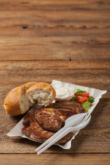 Grilled pork neck served on paper trays.