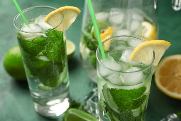Glasses of fresh mojito on green table