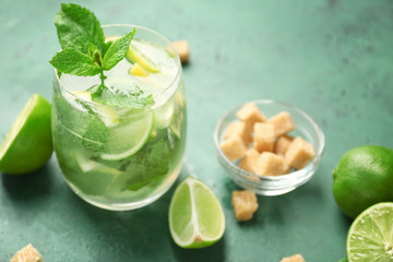 Glass of fresh mojito on green table