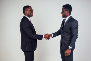 handshake wiht African american bank manager and dark-skinned owner ceo business man in the studio...