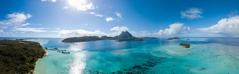 Panorama-Luftbild von luxuriösen Überwasservillen mit Palmen, blauer Lagune, weißem Sandstrand und Otemanu-Berg auf der Insel Bora Bora, Tahiti, Französisch-Polynesien (Bora Bora Aerial)
