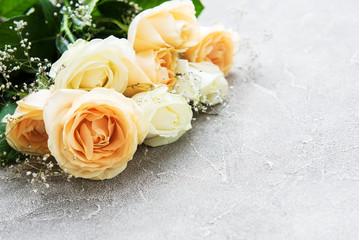Yellow and white roses on a stone background
