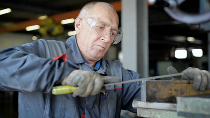 An elderly man in production. The worker will have a file.