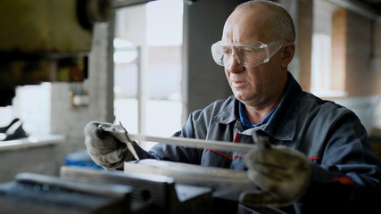 Man in glasses working with metal