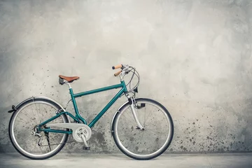 Foto op Plexiglas Fiets Retro fiets met oud bruin leerzadel van circa de jaren & 39 90 voorste betonnen muurachtergrond. Vintage gefilterde foto in oude stijl