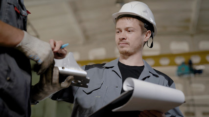 Close-up shot of foreman conducting inspection on plant, looking at the quality of metal details.