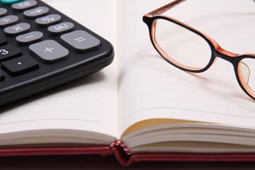 Glasses and calculator with open notebook