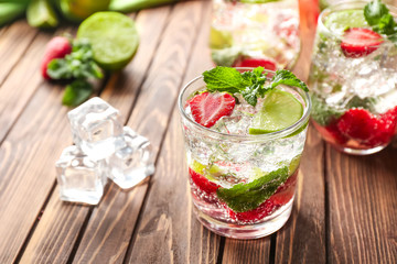 Glass of fresh strawberry mojito on wooden table