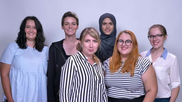 young caucasian females closely standing with smile and happy faces inside