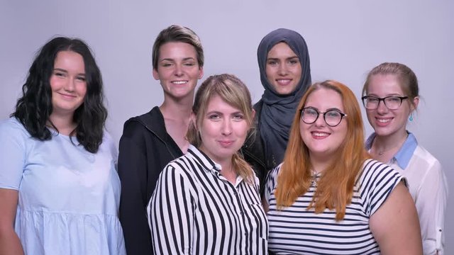 Happy caucasian unlike women stand together chilling and smiling indoor