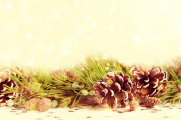 Christmas decor background. Natural pine branches with cones line, sparkling candle light bokeh, retro card. 
