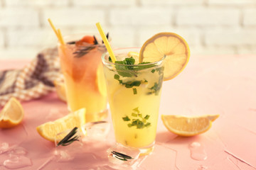 Glasses of cold tasty cocktails on color textured table