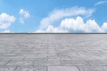 Empty stone floor under blue sky and white clouds