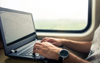 Man working on laptop in a train
