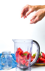 Man adding tomato slices in a blender for a smoothie