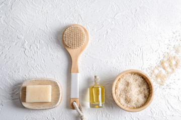 Fototapeta na wymiar Bath products with brush on white textured background