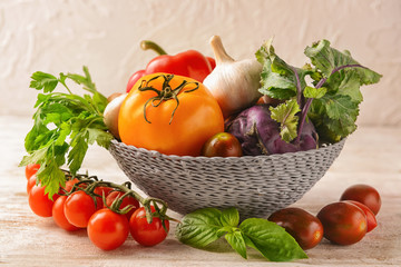 Wicker bowl with various fresh vegetables on table