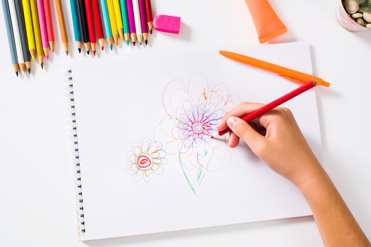 Girl drawing a colorful flower first person