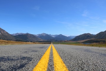 Stra&szlig;e mit gelben Mittelstreifen und Panorama Berge Landschaft Neuseeland