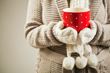 Close up of a person holding a red tea cup