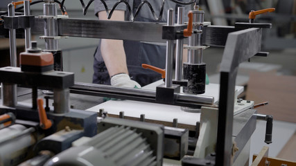 Close up shot of a man operating on machine for wood on a factory.