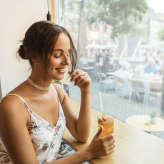 young brunette having ice tea at a café 