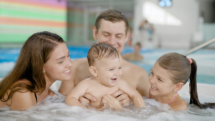 Happy family sitting in jacuzzi