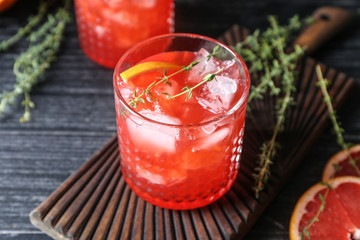 Glass of refreshing grapefruit lemonade on wooden table