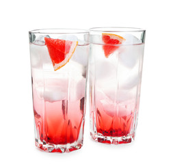 Glasses of refreshing grapefruit lemonade on white background