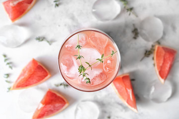 Glass of refreshing grapefruit lemonade on table, top view