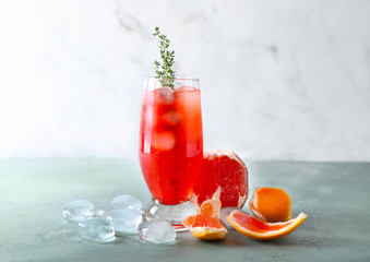 Glass of refreshing grapefruit lemonade on table