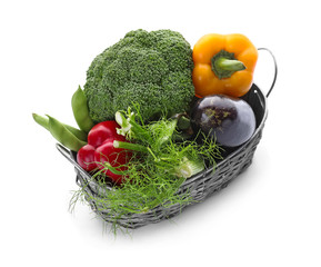 Wicker basket with various fresh vegetables on white background