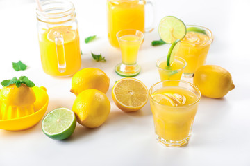 Glasses of fresh lemon juice on light background