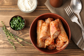 Bowl with stuffed cabbage leaves on wooden table