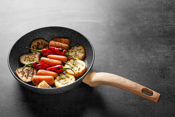 Pan with tasty grilled vegetables on grey table