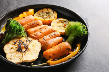 Pan with tasty grilled vegetables on grey table