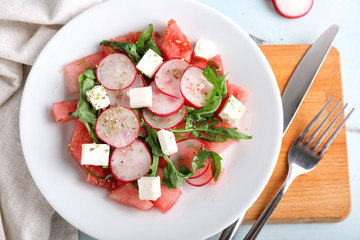 Plate with delicious watermelon salad on table, top view